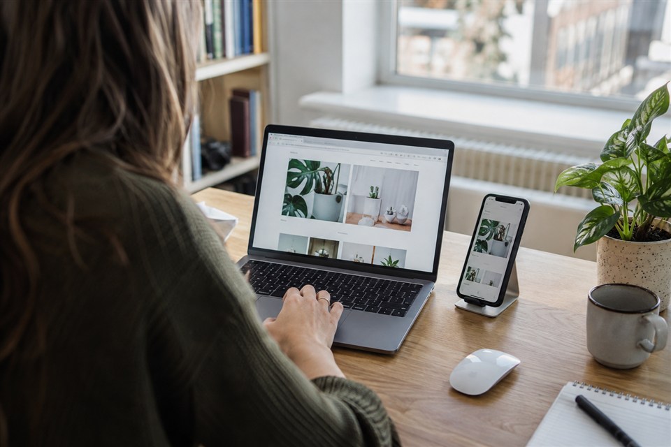 Designer testing a website on a laptop and phone